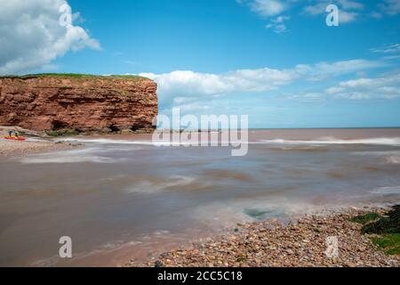 Long exposure of the the mouth of the Otter estuary flowing into the sea on Budleigh Salterton beach Stock Photo