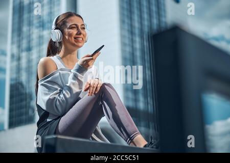 High-spirited lady holding a phone in her hand Stock Photo