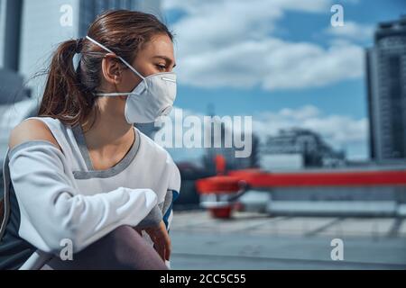 Woman wearing a mask in the city center Stock Photo