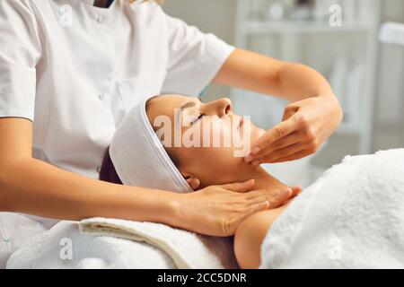 Facial massage or treatment for young womans face in beauty spa salon, side view Stock Photo