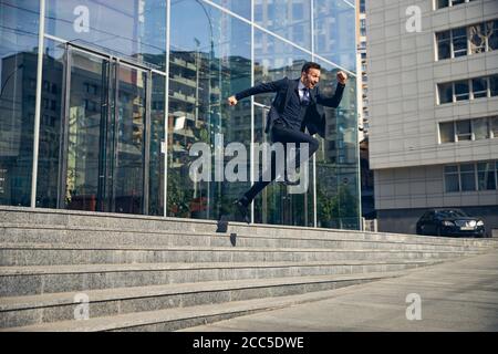 Happy brunette male jumping down in hurry Stock Photo