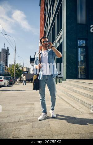 Delighted young male person waiting for his colleague Stock Photo
