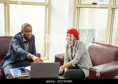 Young black businessman and woman discussing business using a laptop Stock Photo