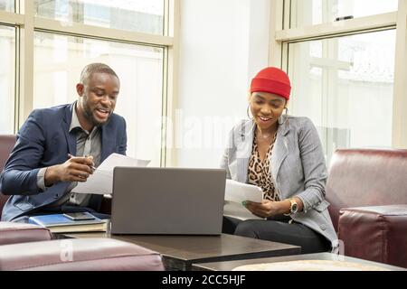 Young african businessman and woman going through some paperwork together Stock Photo