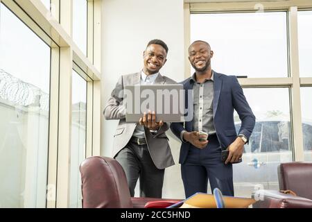 Young black businessmen standing together smiling Stock Photo