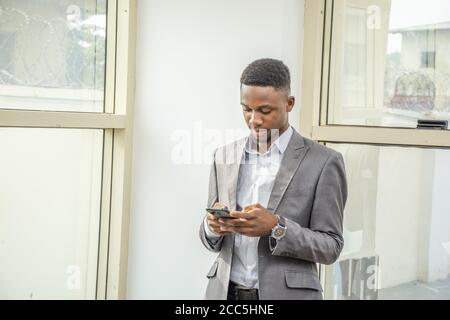 Young black businessman using his mobile phone Stock Photo
