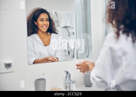 Woman with a happy smile standing in the bathroom Stock Photo