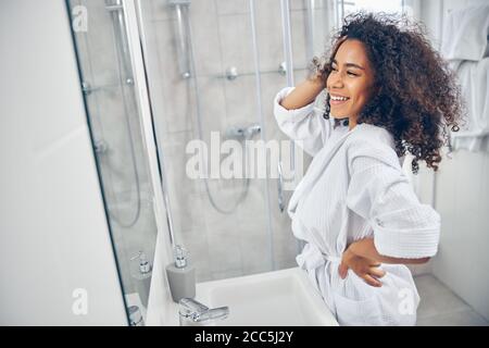 Happy young woman standing in the bathroom Stock Photo