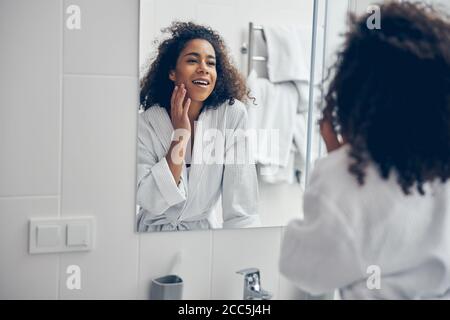 Pleased woman looking at herself in the mirror Stock Photo