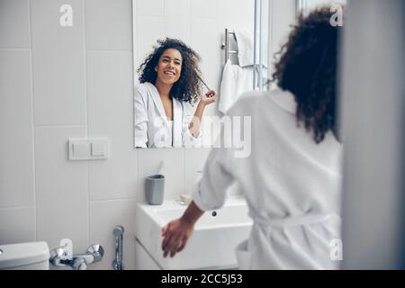 Contented cute lady standing in the bathroom Stock Photo