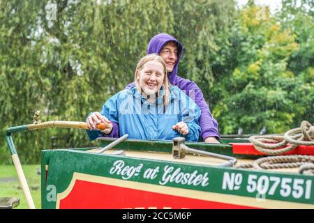 Kidderminster, UK. 19th August, 2020. UK weather: a staycation takes a turn for the worse with heavy rain soaking these holidaymakers. Rob and his family are still all smiles as they navigate their way along the canals of Worcestershire on a relaxing boating holiday in the UK. Credit: Lee Hudson/Alamy Live News Stock Photo