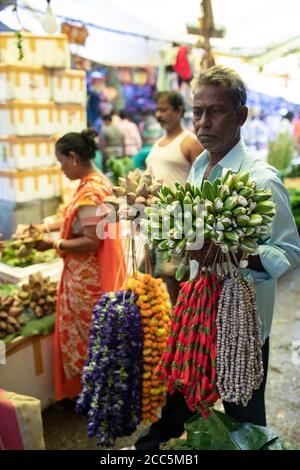 Vendors buy and sell beautiful garlands of marigold and lotus flowers at the Mullick Ghat Flower Market in Kolkata (Calcutta), India, South East Asia. Stock Photo