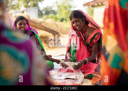 Women save and lend amongst each other in a village savings and loan micro-finance banking group in rural Bihar, India, South East Asia. Stock Photo