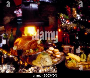 Soft focus Christmas food on table near glowing fire. Stock Photo