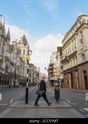 Lawyer or barrister walking to work amid lockdown outside Royal Courts of Justice in London City. Stock Photo