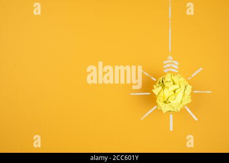 light bulb made of crumpled-up yellow paper on orange background, idea and innovation concept Stock Photo
