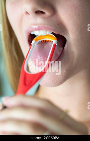 Bad breath, prevention by cleaning the tongue with a tongue brush Stock Photo