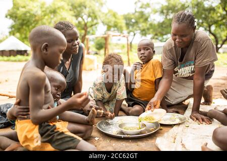 A family from South Sudan shares a meal together in Palabek Refugee Settlement in northern Uganda, East Africa. Stock Photo