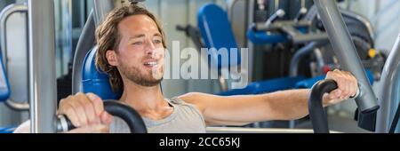 Man doing chest exercises on bench press machine Stock Photo