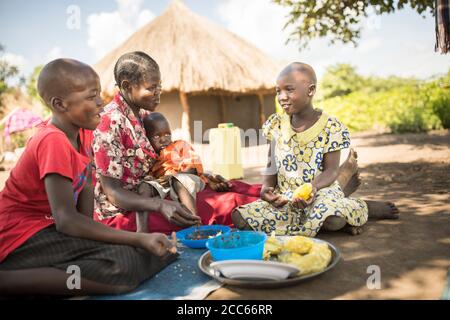 A family from South Sudan shares a meal together in Palabek Refugee Settlement in northern Uganda, East Africa. Stock Photo