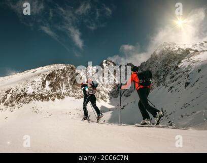 Two women ski walkers go up on the mountain top. Stock Photo