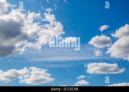 Looking up at blue sky and fluffy white clouds Stock Photo