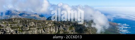 Panoramic view along Table Mountain ridge looking down to sea fog over Atlantic Ocean, Cape Town, South Africa Stock Photo