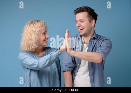 Mother and son giving high five to each other, clapping hands Stock Photo