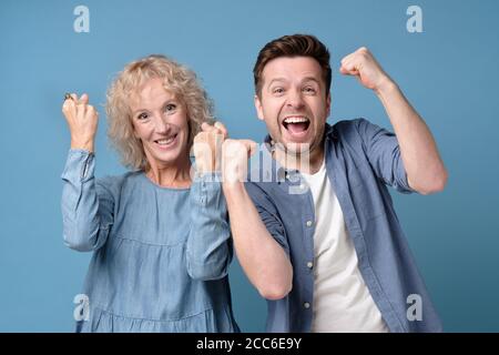 Mother and son celebrating victory raising fists up Stock Photo