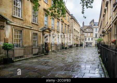 Terrace of Georgian houses with wet reflective flagstones in North Parade Buildings, Bath, Somerset, UK on 19 August 2020 Stock Photo