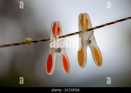 Close-up photography of two plastic clip clothes hangers attached to a cord in a cloudy day in a farm near the town of Arcabuco, in the Andes Stock Photo