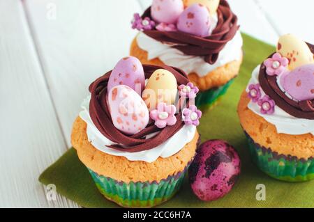 Closeup of Easter nest shape cupcakes on light wooden background Stock Photo