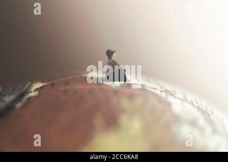 dreaming woman looks at the infinite sitting on a giant globe Stock Photo