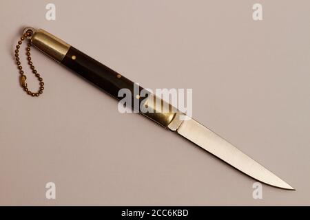 Folding knife with blade fixation on white. Folding knife for use in gardening. Folding knife isolated on grey background. Stock Photo