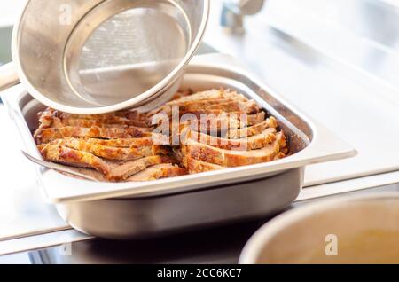 kitchen funnel serving creamy sauce on pork Stock Photo
