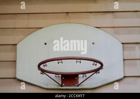 Old basketball backboard and basket. Deserted basketball backboard on a background of plastic. Small basketball hoop made of durable plastic and iron. Stock Photo
