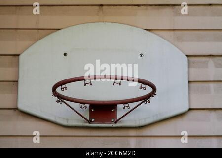 Old basketball backboard and basket. Deserted basketball backboard on a background of plastic. Small basketball hoop made of durable plastic and iron. Stock Photo