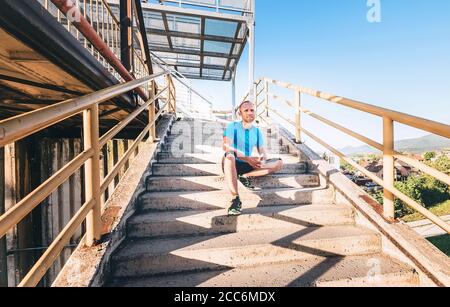 Man sits on stairs after workout set Stock Photo
