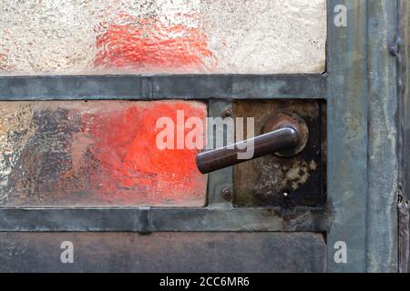 Close up of a old rusty door handle on a glass door in a abandoned greenhouse Stock Photo