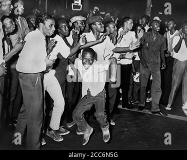 Crowd chanting and Taunting Police after rioting due to fatal shooting of Teen James Powell by Police Officer Lt. Thomas Gilligan, Harlem, New York, USA, Stanley Wolfson, World Telegram & Sun, July 1964 Stock Photo