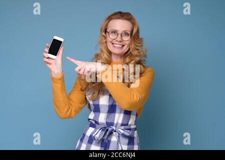 Housewife mother wearing kitchen apron showing a phone with empty screen Stock Photo