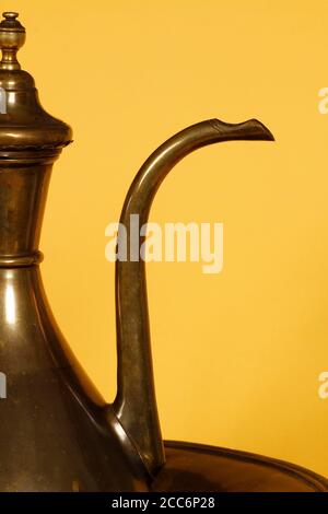 Antique ewer used to heat water by burning coal underneath. The ewer is heated in a coal fire by adding water for various purposes. Stock Photo