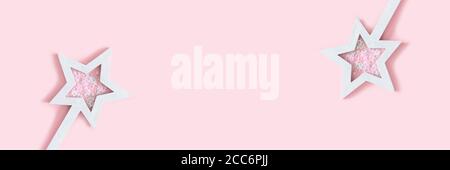 Star shaped magic wands with sequins on a pink background. Creative banner with copy space. Stock Photo