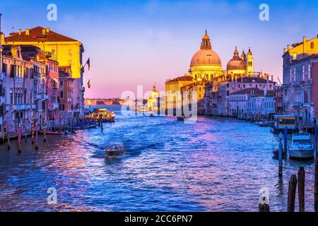 Colorful Grand Canal and Santa Maria della Salute church under sunset with reflections in Venice Italy creates a classic view Stock Photo