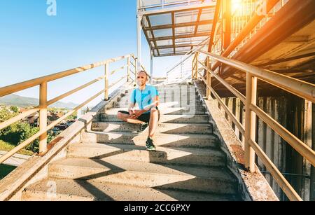 A man sits on stairs after workout set Stock Photo