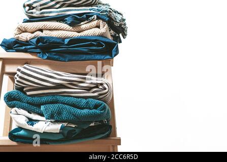 Towels, blankets and other home textile in blue and beidge colors are on the stool Stock Photo
