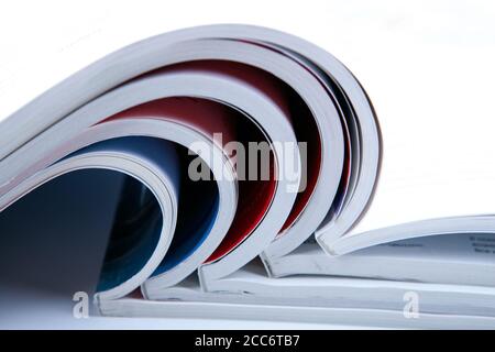 stack of open glossy magazines on white background closeup Stock Photo