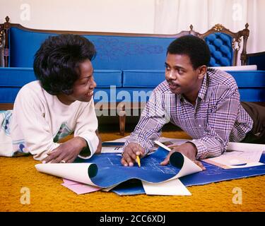 1960s 1970s SMILING AFRICAN-AMERICAN COUPLE LOOKING EYE-TO-EYE LYING ON LIVING ROOM FLOOR GOING OVER NEW HOME BLUEPRINT PLANS - ks5713 HAR001 HARS OLD FASHION 1 COMMUNICATION TEAMWORK INFORMATION BLUEPRINT PLEASED JOY LIFESTYLE SATISFACTION FEMALES HOUSES MARRIED SPOUSE HUSBANDS HOME LIFE PLANS COPY SPACE FRIENDSHIP LADIES PERSONS RESIDENTIAL MALES BUILDINGS CONFIDENCE PARTNER GOALS DREAMS HAPPINESS HEAD AND SHOULDERS CHEERFUL AFRICAN-AMERICANS AFRICAN-AMERICAN EXCITEMENT LOW ANGLE BLACK ETHNICITY PRIDE ON OPPORTUNITY HOMES SMILES CONNECTION CONCEPTUAL JOYFUL RESIDENCE STYLISH SUPPORT Stock Photo