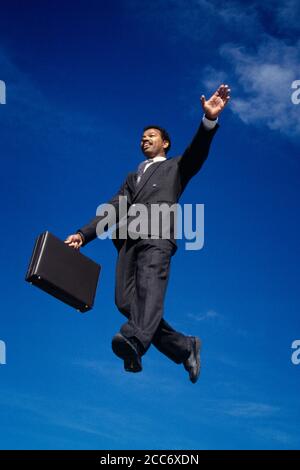 1990s SMILING HAPPY AFRICAN-AMERICAN BUSINESSMAN WEARING SUIT AND TIE JUMPING IN WALKING ON MID AIR WITH BRIEFCASE  - ks37063 DEL003 HARS MAGIC OLD TIME NOSTALGIA OLD FASHION 1 CAREER BALANCE LEAPING JOY LIFESTYLE SATISFACTION SALESPERSON CELEBRATION VERTICAL GROWNUP COPY SPACE FULL-LENGTH GROWN-UP PROFESSION CONFIDENCE AMERICANS RELEASES FREEDOM GOALS SUCCESS WHITE COLLAR DREAMS OCCUPATION SELLING HAPPINESS ADVENTURE LEAP AFRICAN-AMERICANS COURAGE AFRICAN-AMERICAN EXCITEMENT LEADERSHIP LOW ANGLE PROGRESS ETHNIC DIVERSITY AFRO-AMERICAN INNOVATION PRIDE AFRO-AMERICANS OPPORTUNITY OCCUPATIONS Stock Photo