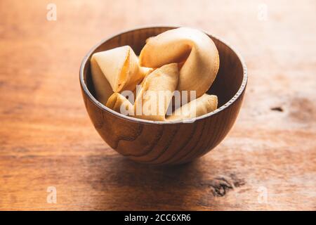 Chinese lucky cookies. Fortune cookies in wooden bowl. Stock Photo